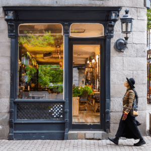 A woman walking past a coffee shop.